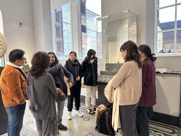 group of students standing in front of a museum's display case