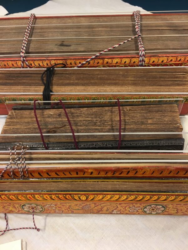 Photograph showing a series of books standing next to each other, bound by string