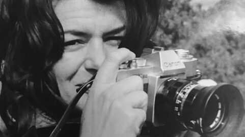 Black and white portrait of Maggie Keswick Jencks holding a camera