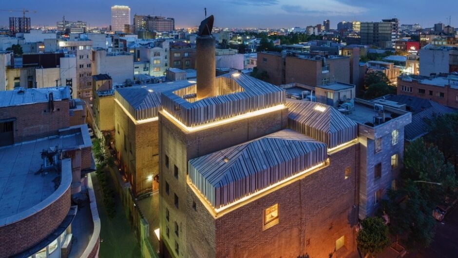Photograph of the roofs of large city buildings at night.