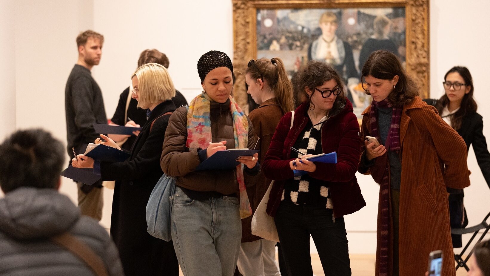 A group of people stand in front of Manet's A Bar at the Folies Bergère painting at The Courtauld
