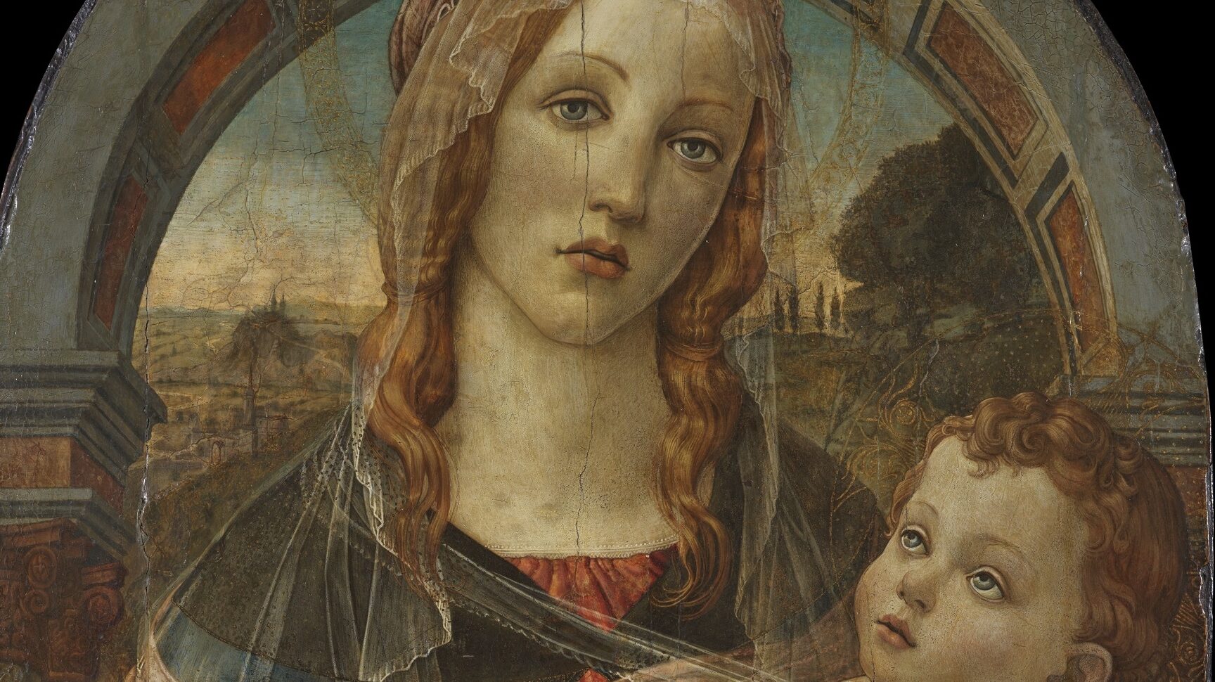 Oil painting of a Virgin and Child, with the Virgin standing in front of an archway wearing an orange-red dress and blue cape holding an infant lightly swaddled. The colours are vibrant but the panel visibly worn.