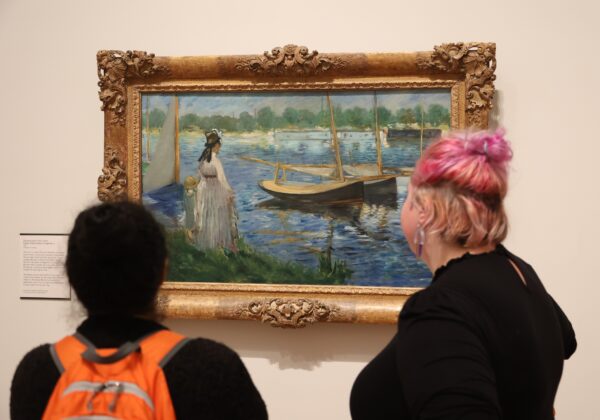 Two visitors look at a painting by Seurat