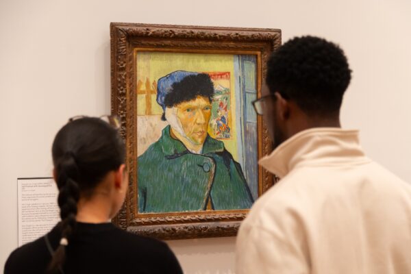 Two visitors look at Van Gogh's self portrait with bandaged ear