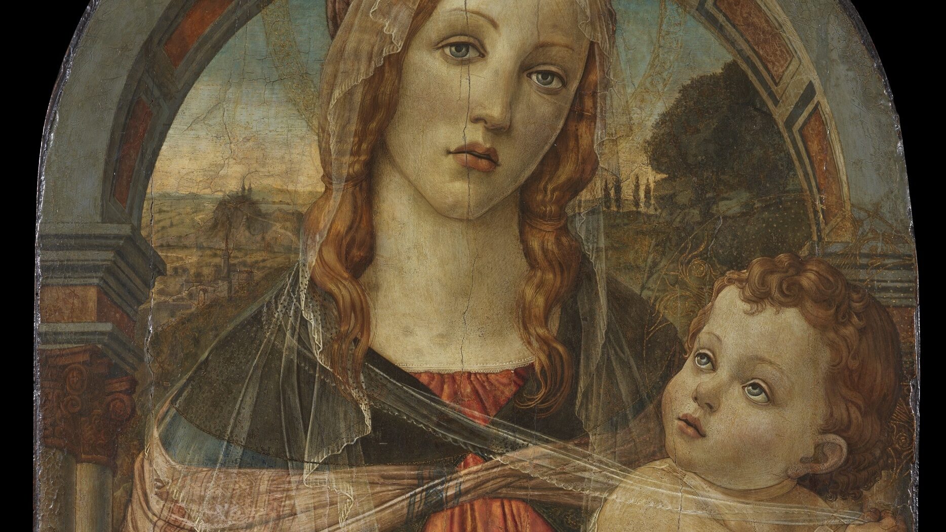 Oil painting of a Virgin and Child, with the Virgin standing in front of an archway wearing an orange-red dress and blue cape holding an infant lightly swaddled. The colours are vibrant but the panel visibly worn.