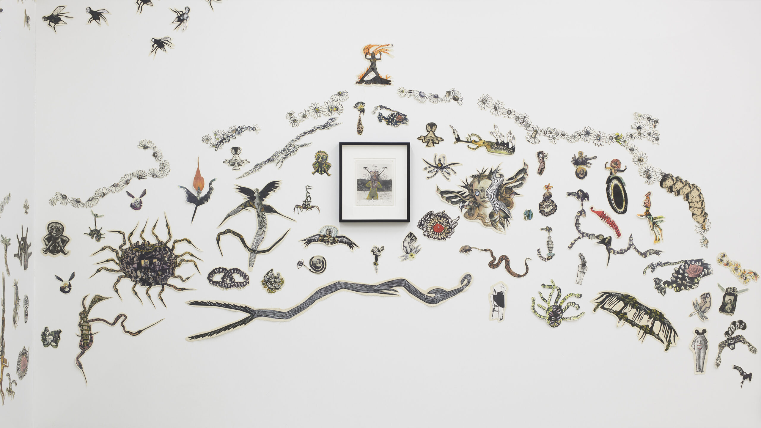 Photograph of an installed artwork, consisting of paper pictures of animals and insects stuck on a wall