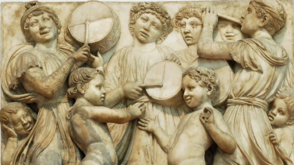 A marble relief showing a group of boys playing musical instruments.