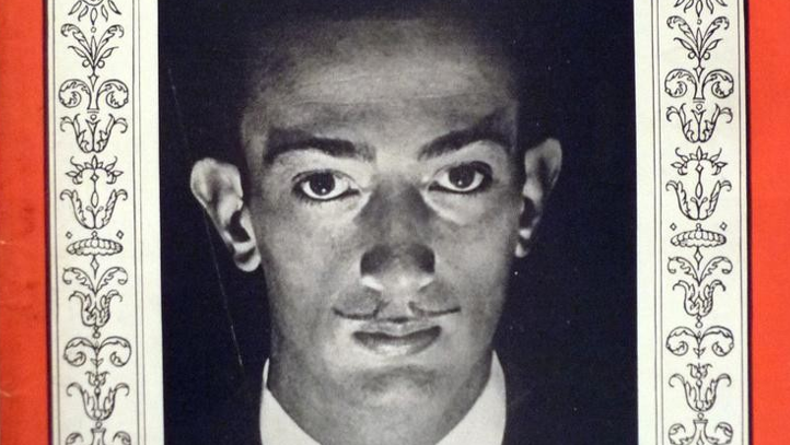 Picture of Time Magazine cover bordered in red. In the centre is a photograph of a man in a suit and tie looking directly at the camera. He is lit from below making shadows fall across his face.