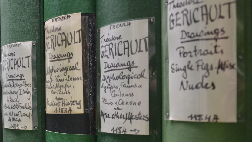 close up image of four photo books, green fabric binding them and the labels all handwritten to show group and location, as well as library numbering system.