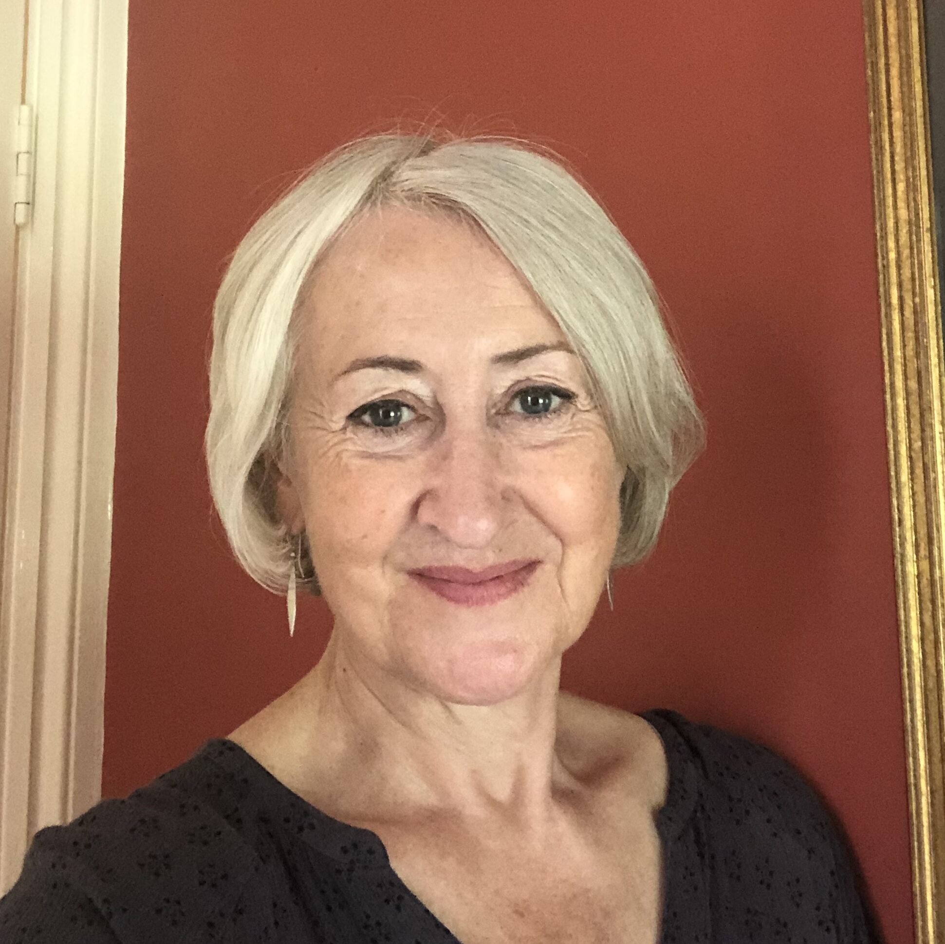 portrait of a woman with blond hair smiling at the camera