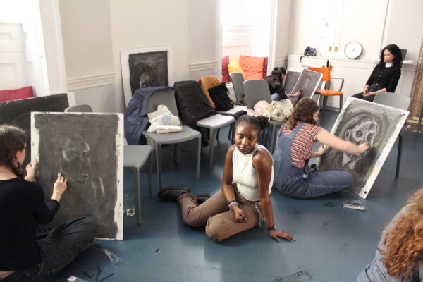 a class of young students drawing portraits of each other