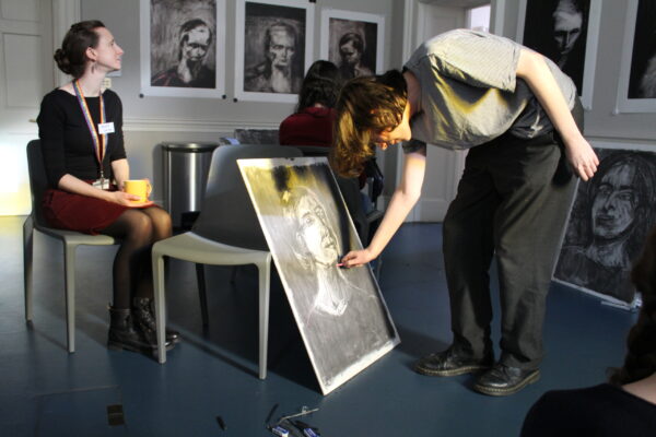 a young male student drawing a portrait of one of the Courtauld's educators