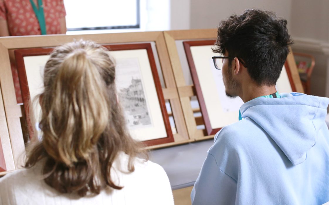 Two students looking at two drawings. Part of the summer university programme.