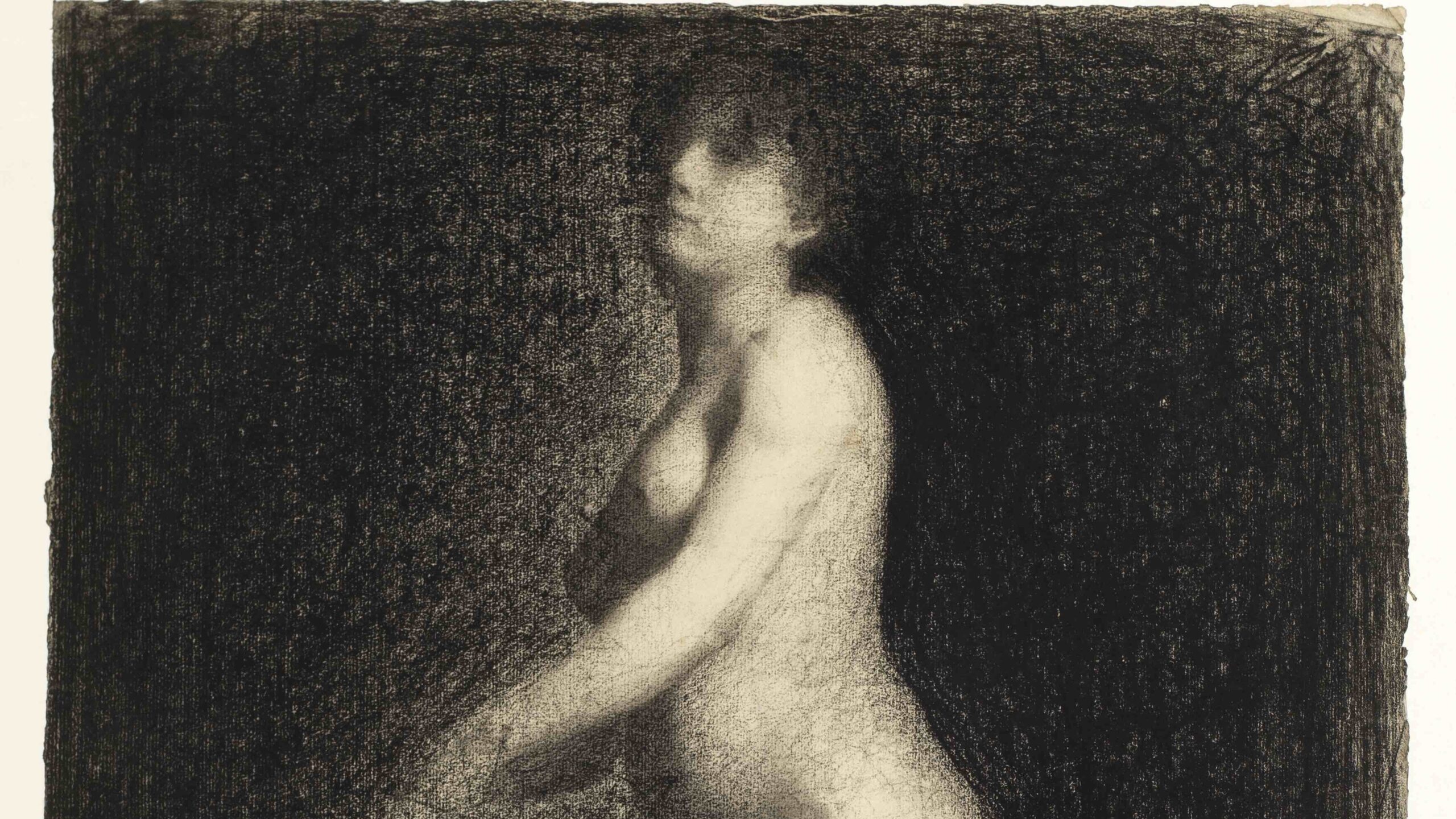 A drawing of a nude woman, seemingly kneeling on a chair, although the chair is not visible. The background is completely dark with the figure contrasting in light colours. Both legs and arms fade into the edges of the paper, and there are no harsh lines.