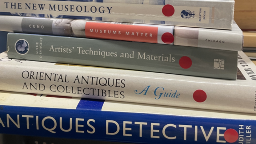 A pile of books about art standing on a table
