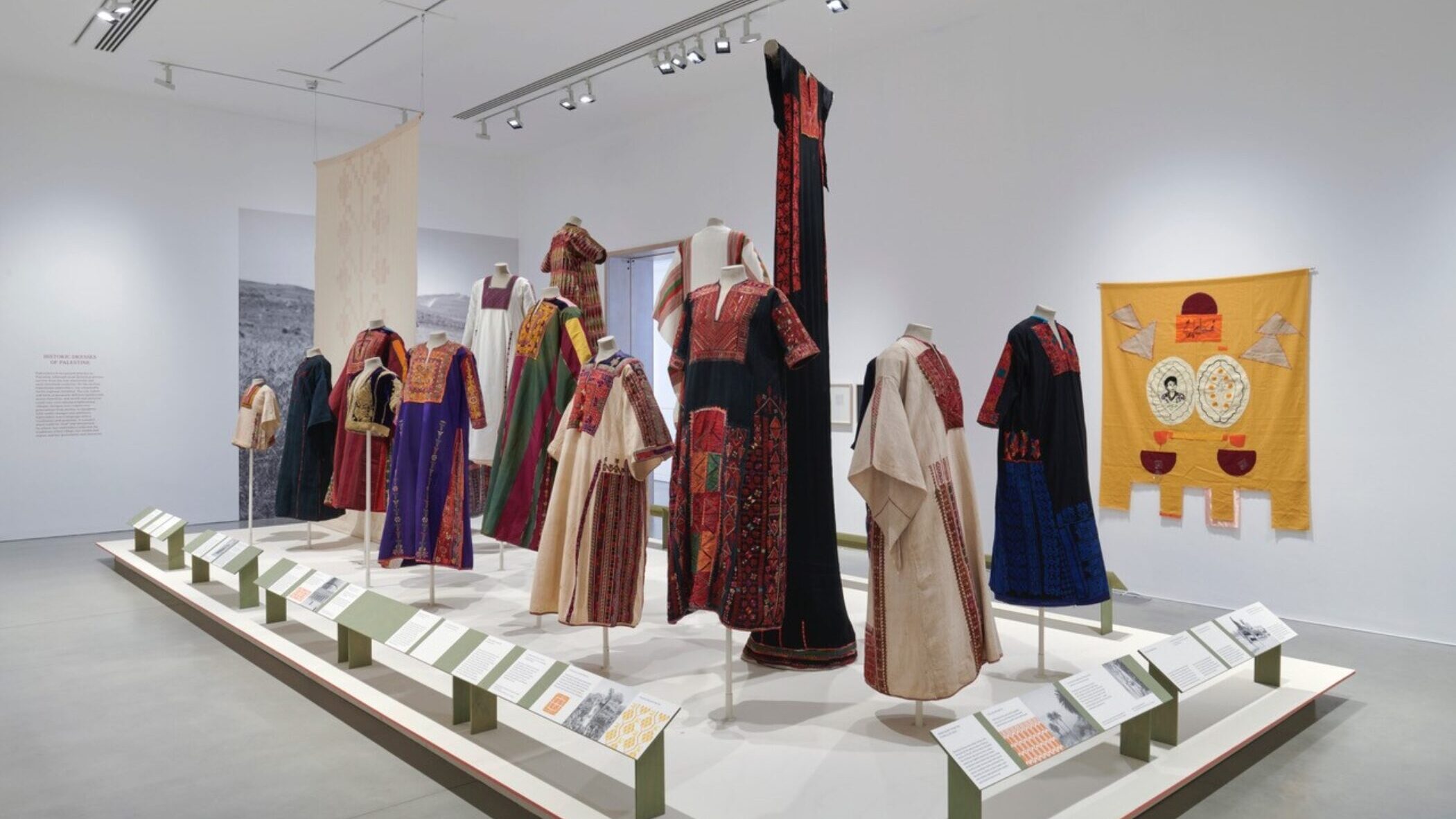 A gallery room full of embroided dresses standing on plinths