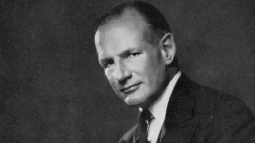 Black and white photograph of Samuel Courtauld, wearing a suit and sitting down, looking straight at the camera