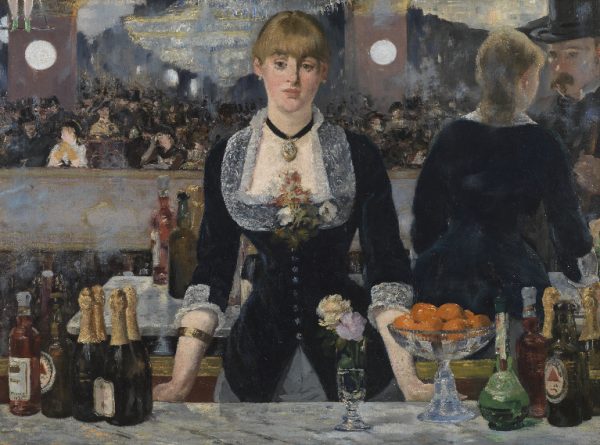 A woman standing behind a bar facing straight ahead.