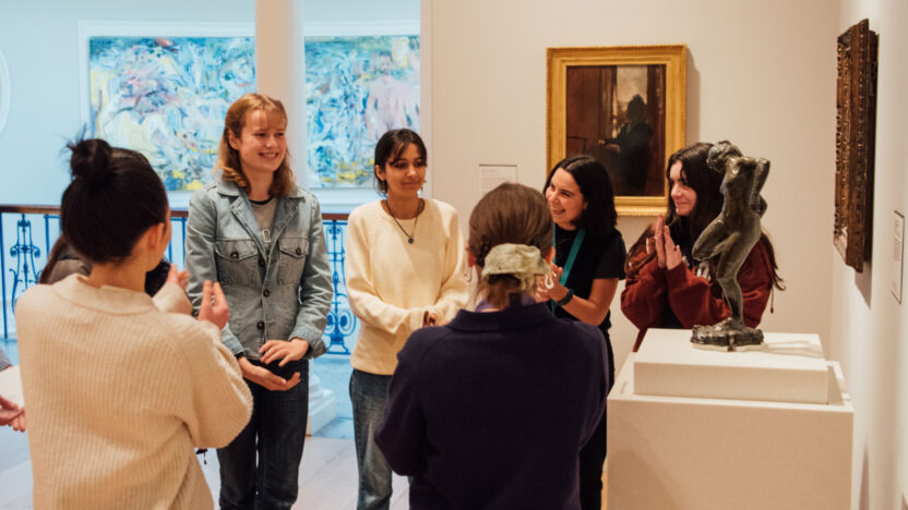 A group of student gathering in an art gallery around a work of art