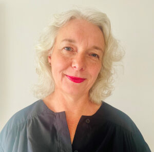 Stephanie Dieckvoss looking at the camera with red lipstick and a black blouse