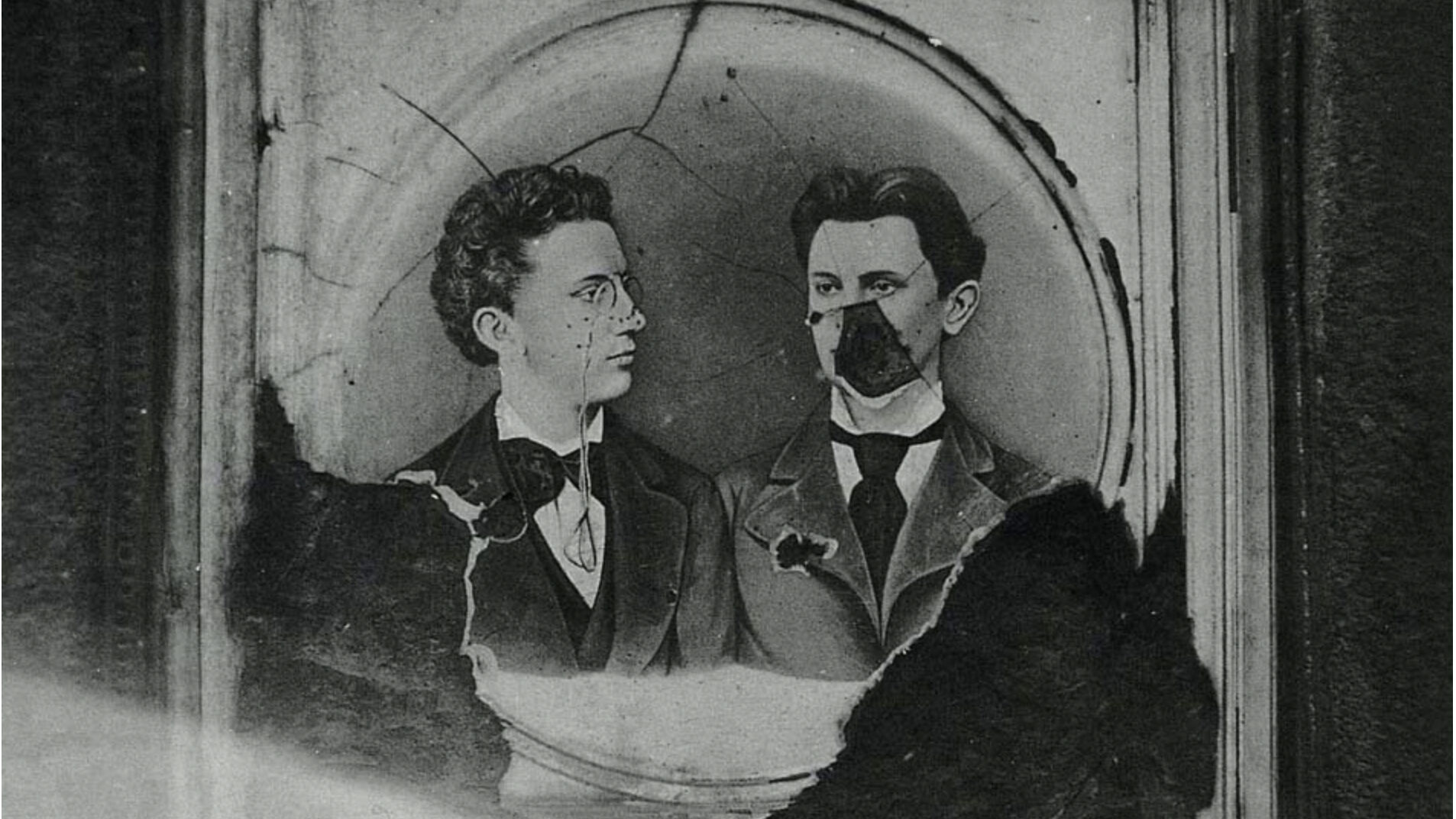 a broken glass plate negative of two male figures in victorian dress, black and white