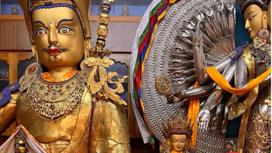 shrine featuring large gold sculptures with candles and votives