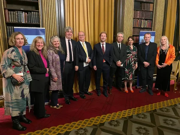 A group of people, including Tom Young, smile in a row at The Walpole Society as they present the prize. They are all dressed smartly, and stand in a grand room at The Walpole Society.