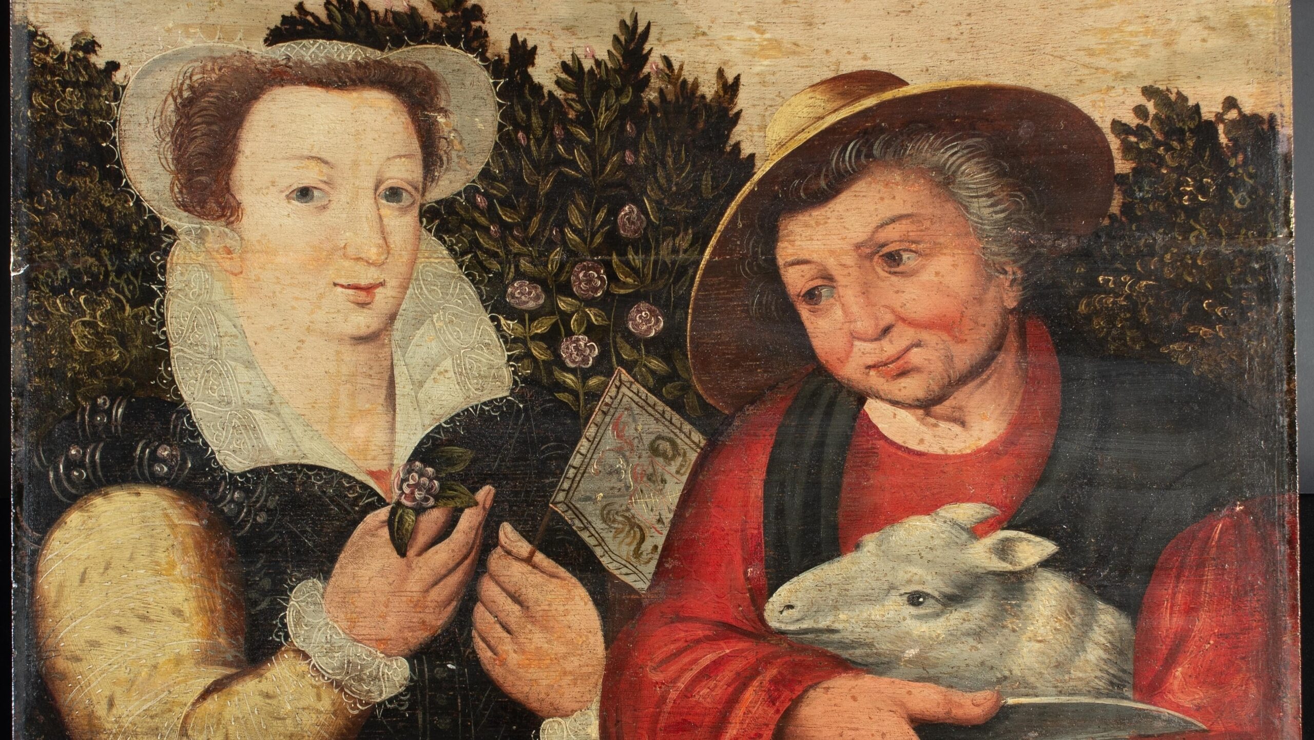 An early-modern oil painting shows two women in a garden. The woman on the left, dressed in rich, elegant clothing, is likely part of the nobility. She holds a flower in one hand and a banner in the other. The older woman on the right, dressed in gardening clothes, cradles a lamb in her arms and holds a pair of shears.