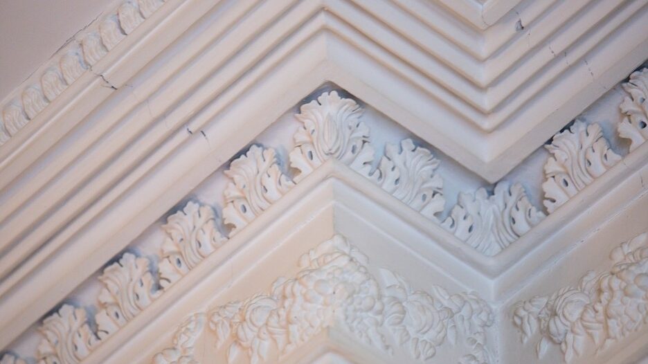 Decorative cornices in white, featuring rows of acanthus leaves and fruit swags.