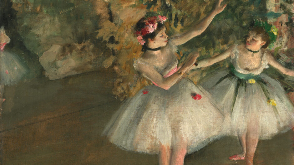 Two girls dance on stage. They wear leotards; one girl bows to the other.