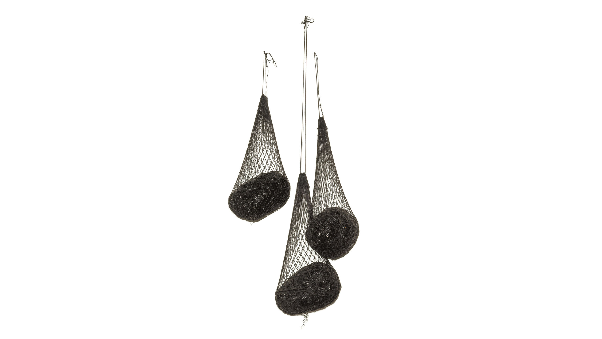 Sculpture with three dark nets hanging