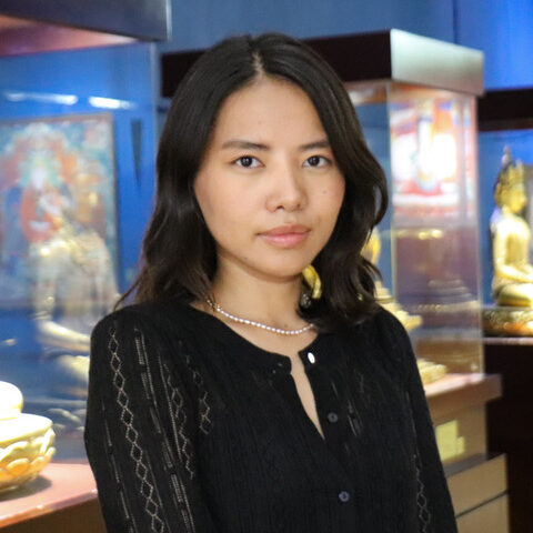 portrait of a young woman in a black top in a museum