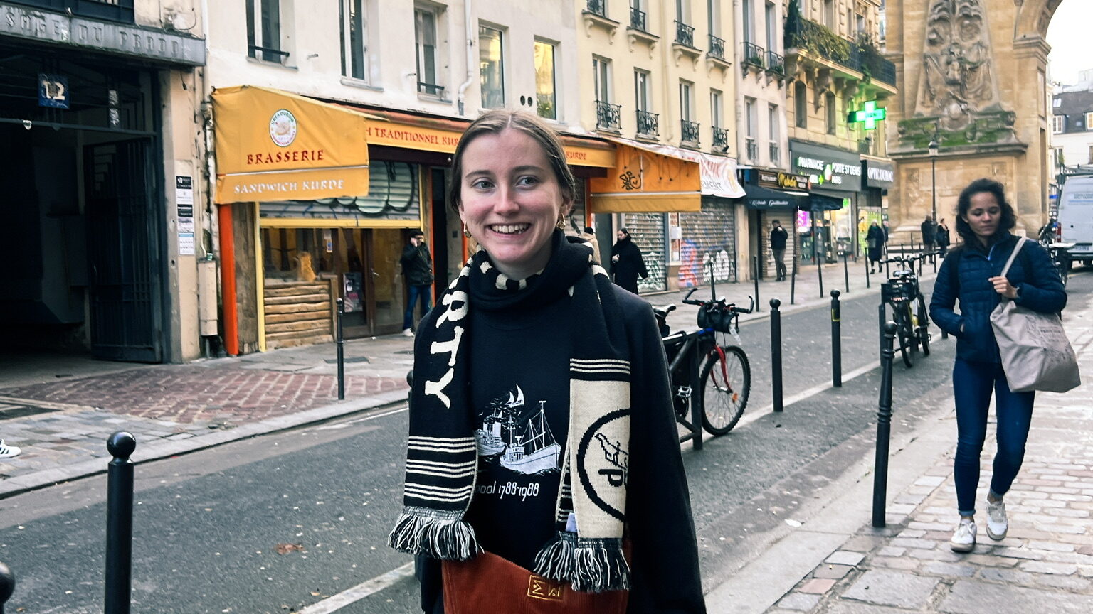 Ellen standing on a street in Paris, smiling.