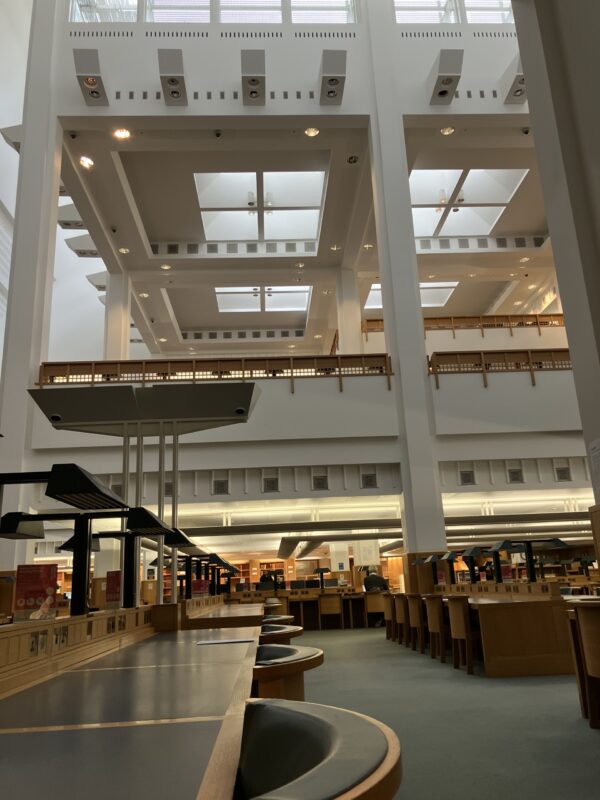 The British Library space, with historic leather-bound desks shown in a large open library room with high ceilings.