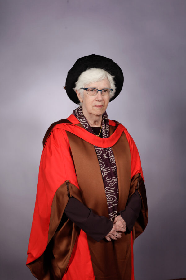 Dr Helen C. Evans at The Courtauld Graduation, wearing a brown gown with a red trim and graduation cap