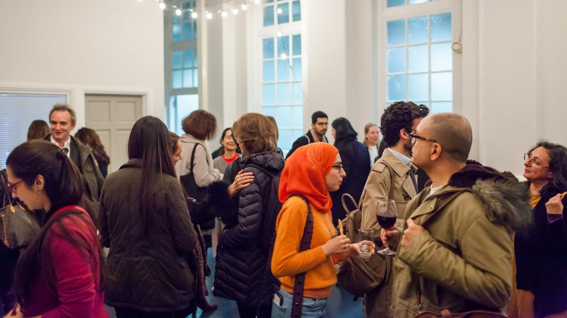 group of visitors chatting in a room whilst waiting for a research forum event