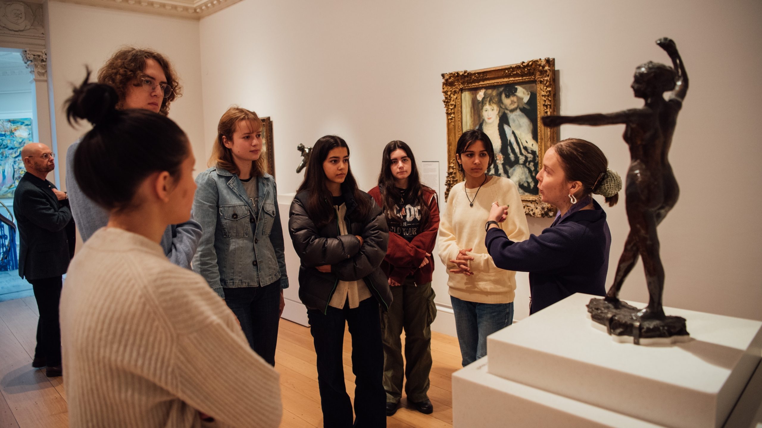 Students from Art History Link-Up are being taught in front of a statue, part of The Courtauld collection