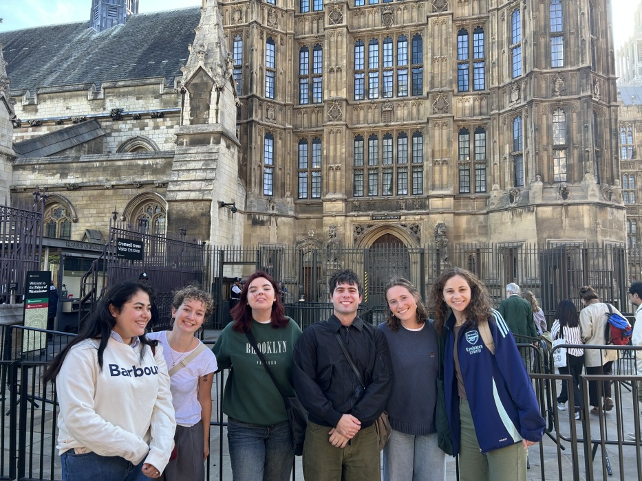 A group of six students stand together outside Parliament