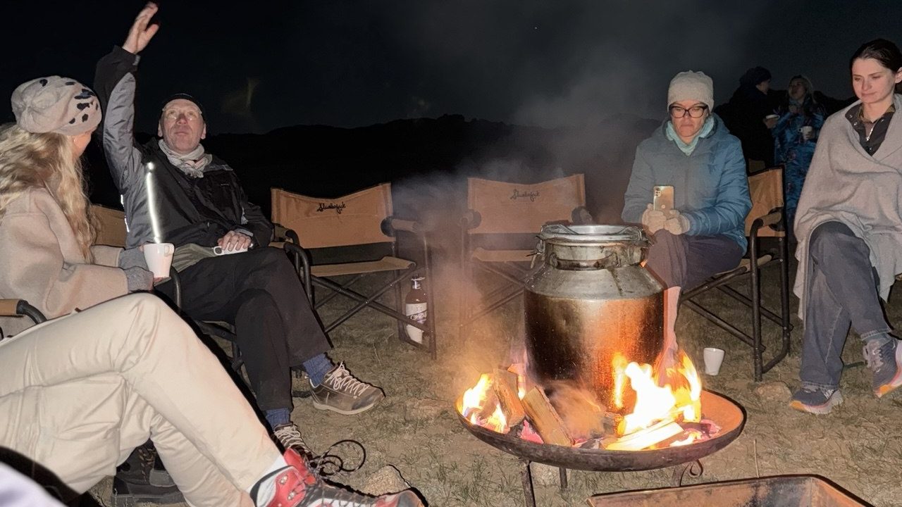 Mongol connections participants converse over an open fire.