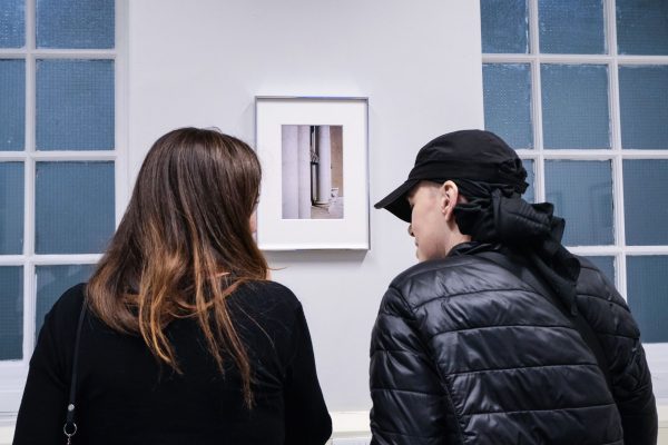 Two women talk and look at an artwork in a classroom.