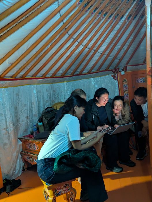 A group sit within a gher, a traditional Mongolian dwelling.