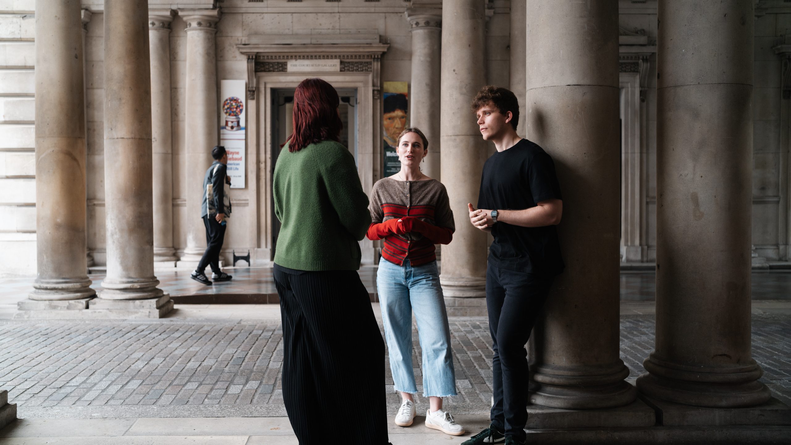 Three students talk in the arches outside Somerset House