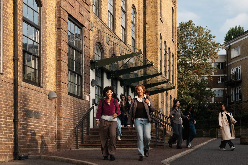 A number of smiling students exit the Courtauld Vernon Square campus.