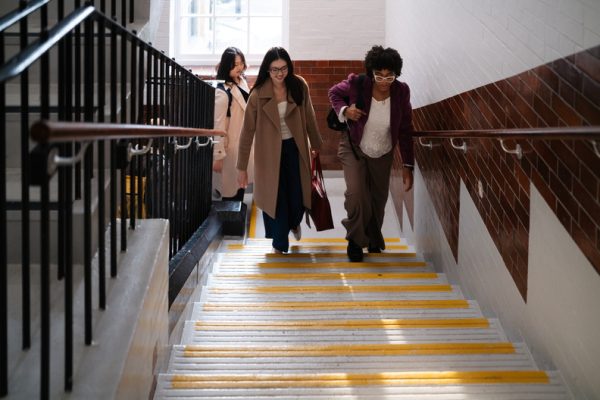 Three students walk up stairs at Vernon Square campus.