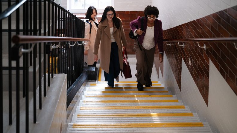 Three students walk up stairs at Vernon Square campus.