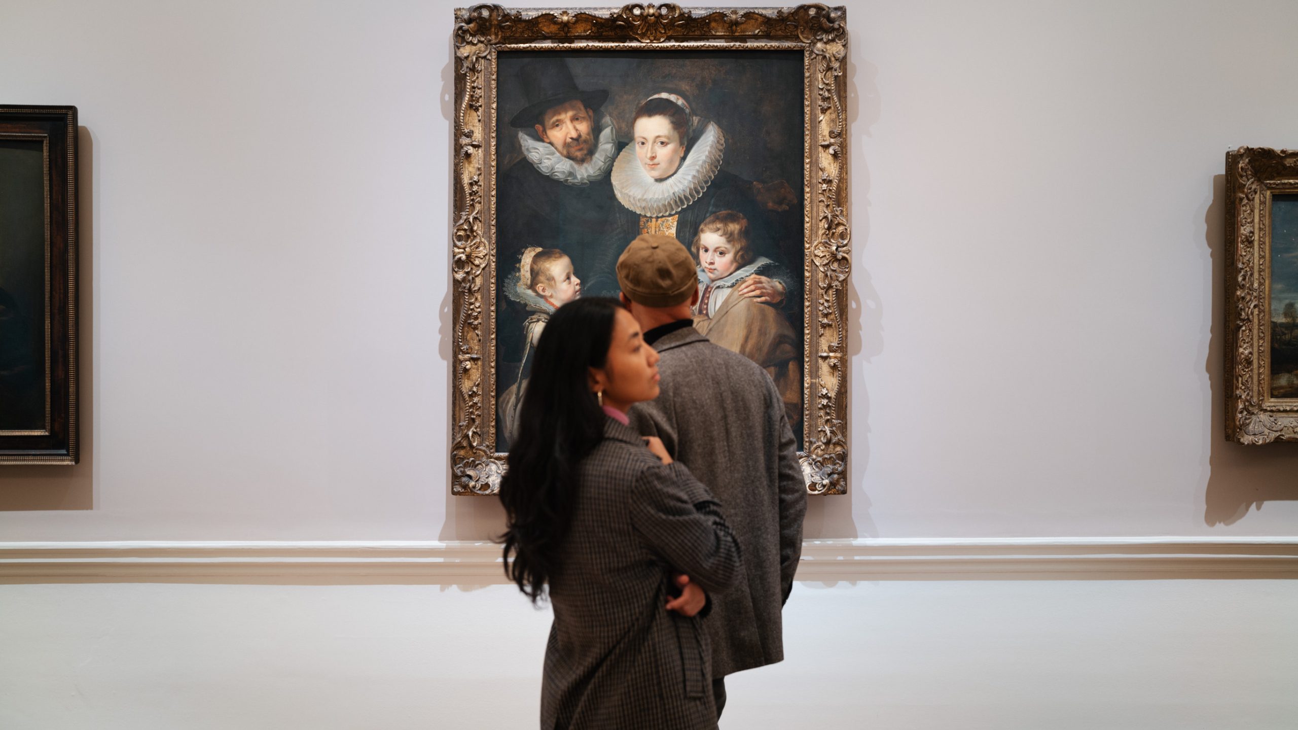 A woman and a man in front of a painting.