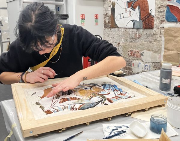 One student works on restoring an artwork.