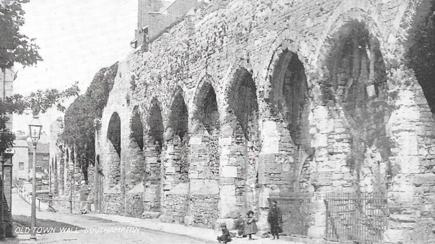 Black and white photograph of Southampton Old Town Wall, with three children by it