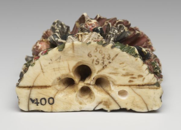 ceramic base of a glazed sculture depicting Jesus praying in the garden of Gethsemane. seated sleeping disciples sit beneath him.