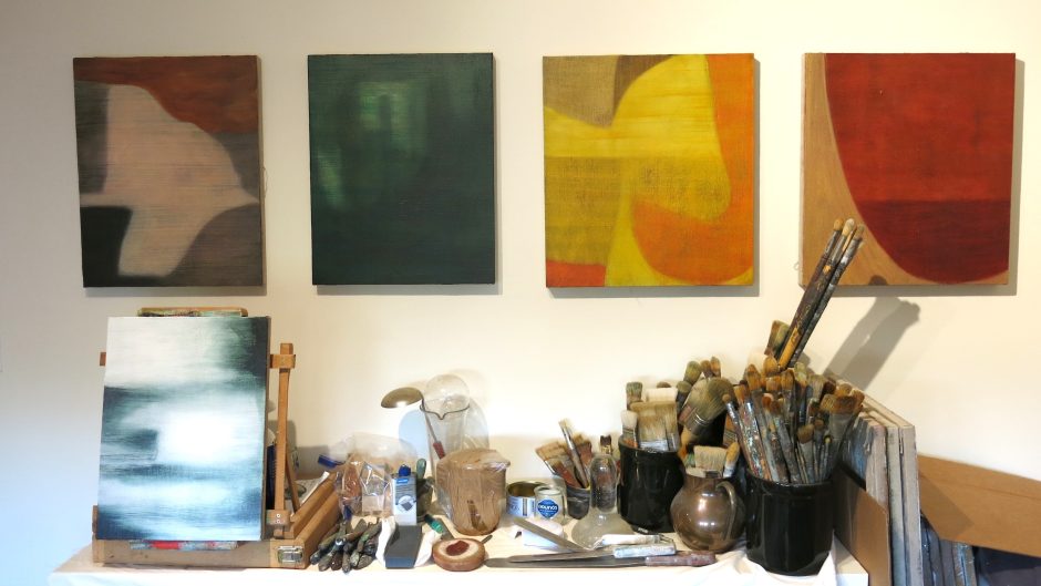 Interior view of Kurt Christian’s studio in New Jersey, showing canvases in progress leaning against walls and easels, art supplies scattered around, and natural light illuminating a creative, work-in-progress space.